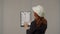 Back view of a woman architect with a apartment plan on a clipboard. A business woman studies the project plan, prepares