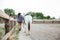 Back view of woman cowgirl walking with horse