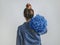 Back view of woman, holding Classic Blue roses