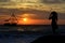 Back view of woman silhouette watching a boat at sunrise