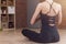 Back view of woman sitting in yoga lotus pose relaxing and meditating in living room