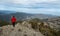 Back view of a woman standing on rocky top y enjoying mountain range panorama. Hiking traveling and climbing