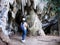 Back view of woman tourist walking into the cave