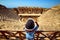 Back view of woman traveler in hat looking at amazing Amphitheater ruins in ancient Hierapolis, Pamukkale, Turkey. Grand panorama