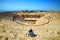 Back view of woman traveler in hat looking at amazing Amphitheater ruins in ancient Hierapolis, Pamukkale, Turkey. Grand panorama