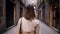 Back view of woman walking alone in Barcelona Gothic Quarter. Old apartment buildings, narrow streets of Europe
