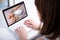 Back view of woman watching blog video about cooking on laptop