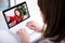 Back view of woman watching blog video on laptop