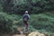 Back view of young Asian adventure man hiking on nature green mountain. Travel lifestyle and relaxation concept.