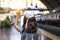 Back view of young Asian tourist girl holding model airplane at train station. Travel lifestyle concept