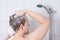 Back view of young attractive man washing hair