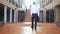 Back of view of young businessman in a suit walks with a briefcase in a business centre.