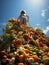 Back View of a Young Child Climbing Up a Bountiful Mountain of Food Piled High Overflowing with Fresh Fruits and Colorful