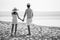 back view of Young couple in love  looking the future   and holding hand together at sea beach  .happy smiling young wedding with