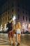 Back view of a young couple of lovers walking the night streets of old italy. Summer evening. Tourism and vacation. Relationships