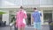 Back view of a young couple with rockets go to hotel. The girl in rose clothes and man in blue sport wear. Active