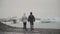 Back view of young couple walking in ice lagoon in Iceland. Man and woman exploring the icebergs and glaciers.