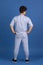Back view of young curly man standing isolated over blue, navy studio background. Copyspace for ad, design. Concept of