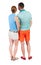 Back view of young embracing couple in shorts hug and look.