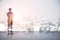 Back view of young european man standing on abstract rooftop white city background with mock up place. Success and leadership