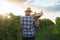 Back view a young farmer man holding box of grapes . Agronomist worker stands in vineyards.