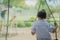 Back view of young girl sit on swing for wait her friend at the