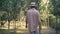 Back view of young happy man walking outdoors in garden turning to camera smiling. Portrait of satisfied male Caucasian