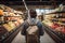 Back view of a young man with a backpack in a supermarket.