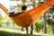 Back view of young man and girl in hammock