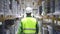 Back view of young man worker walking on industrial warehouse during working day.