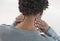 Back view of a young mulatto man with neck pain