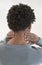 Back view of a young mulatto man with neck pain