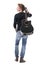 Back view of young rocker musician carrying guitar on shoulder looking up and away for inspiration