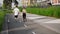 A back view of young sportive family in the morning jog with pet, a Jack Russell Terrier dog, outdoors in the city park