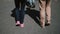 Back view of young stylish couple walking through the street in sunny day. Man and woman holding hands.