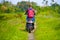 Back view of young tourist afro American black woman riding motorbike happy in beautiful Asia countryside along green rice fields