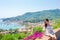 Back view of young woman background stunning town. Tourist looking at scenic view of Cinque Terre, Liguria, Italy