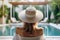 Back view of young woman with long blond hair wearing white straw hat on poolside in her vacation at a beautiful resort. Summer