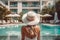 Back view of young woman with long blond hair wearing white straw hat on poolside in her vacation at a beautiful resort. Summer