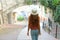 Back view of young woman walking in old medieval town of Perugia, Italy