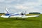 Back view of Zlin Z-43 four-seat airplane standing on a grass runway.