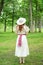 Back of vintage redhead woman with hat in park