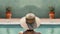 Back of woman by swimming pool wearing wide brimmed hat