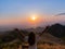 Back woman tourist raise hands up on top hill with beautiful mountain view sunset sky at viewpoint on Doi Samer Dao in Nan,