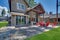 Back yard with fire pit and red chairs near newly bild luxury real estate home with forest biew and green grass