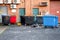 Back yard of an office building with colored rubbish bins, fire doors and utility room entrance. Many air conditioner units