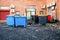 Back yard of an office building with colored rubbish bins, fire doors and utility room entrance. Many air conditioner units