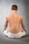 Back of young man in yoga position