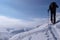 Backcountry skier hikes and climbs to a remote mountain peak in Switzerland on a beautiful winter day
