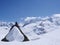 Backcountry skier sitting on top of a large snow-covered rock in midst of a spectacular winter mountain landscape